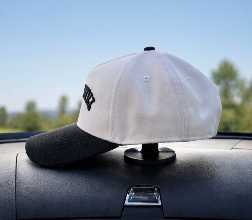 baseball caps on a car dashboard with a blurred outdoor background